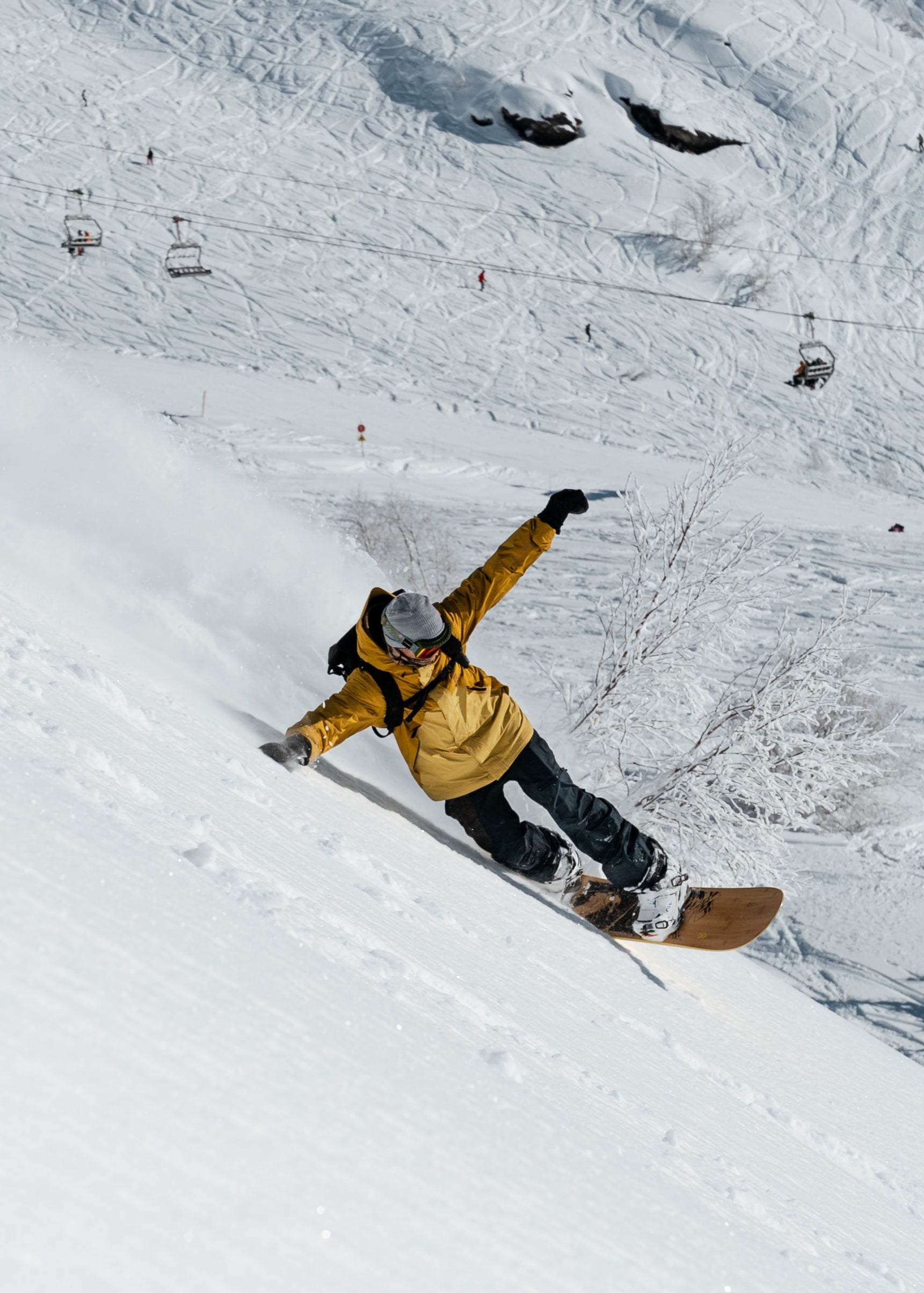 Rider on a Tundra All-Conditions Snowboard floating through deep powder snow in the backcountry.