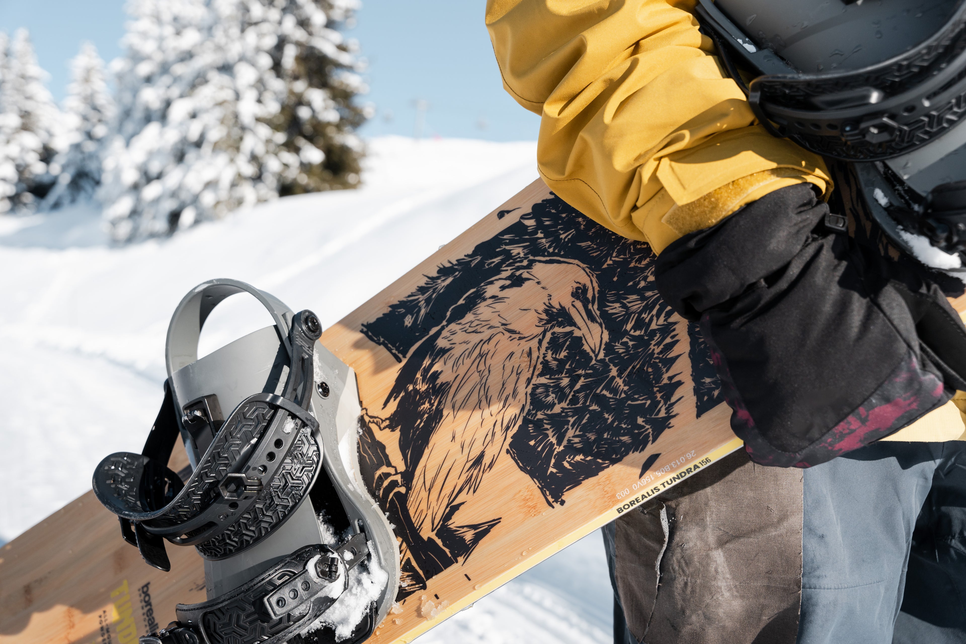 Borealis Tundra being carried by a snowboarder, showcasing its everyday snowboard design and classic graphic.